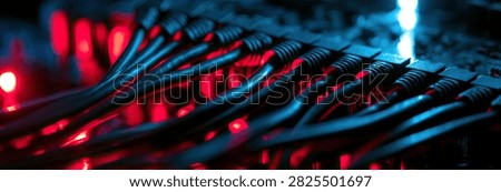 An abstract, macro view of tangled wires illuminated by vibrant red and blue lights, creating a futuristic and technological aesthetic.