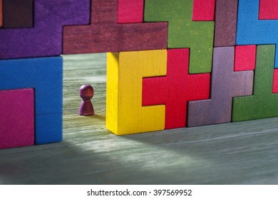 Abstract Man In The Doorway. Colorful Wall Of Wooden Puzzles. Construction Of Tetris Shapes.