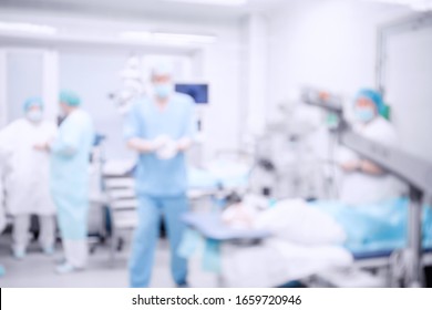 Abstract medical blurred background of operating room, patient lies on table, doctors working.