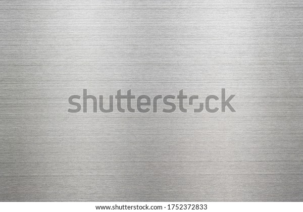 Abstract metal texture of brushed stainless\
steel plate with the reflection of\
light.