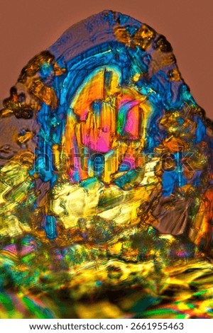 Abstract micrograph of bubbly, birefringent crystals of an amino acid, threonine, with polarization at 400x.