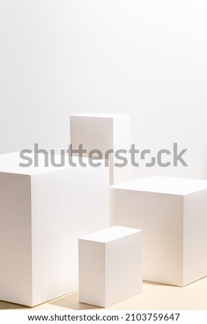 Abstract minimal nature scene - empty stage with four white rectangle podiums on beige background. Pedestal for cosmetic product and packaging mockups display presentation