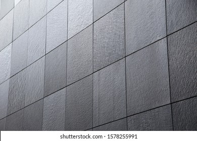 Abstract modern architecture and construction or finishing material background of tiled granite wall. Minimalist building exterior or interior with geometric structure viewed in diagonal perspective.