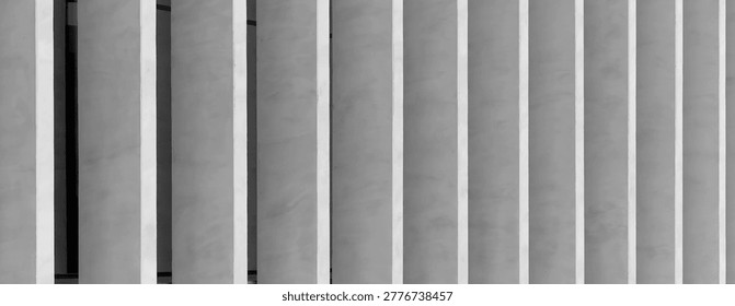 Abstract modern building facade with vertical concrete slats. Minimalist architectural exterior with clean geometric lines. Suitable for urban design, texture, and background use.
