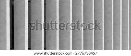 Abstract modern building facade with vertical concrete slats. Minimalist architectural exterior with clean geometric lines. Suitable for urban design, texture, and background use.