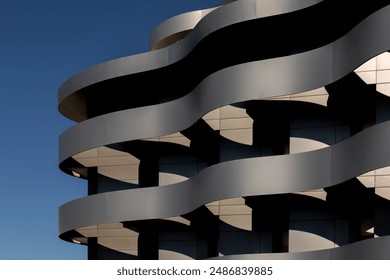 Abstract modern curve architecture background. Daylight building with exterior walls covered with beautiful curved gray metal lines. Contemporary office closeup fragment. Wavy exterior wall facade - Powered by Shutterstock