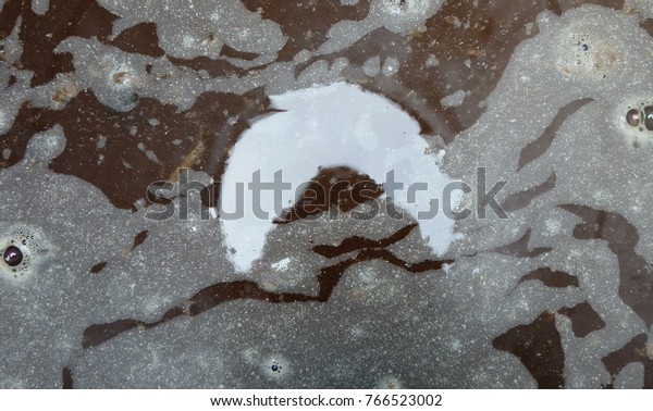 Abstract of the moon shadow, on  background  dirty\
water in the water.