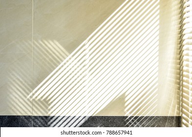 Abstract Of Morning Light And Shadow On Tiled Wall Through Window Blind Shutter. Parallel Lines Of Light And Reflection Provide Interesting Abstract Interior Character. Light Through Blinds Window.