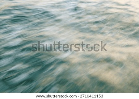 Abstract motion blur of ocean waves in soft light.