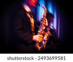 Abstract motion blurred image of a jazz saxaphonist improvising on stage. Jazz music concept.