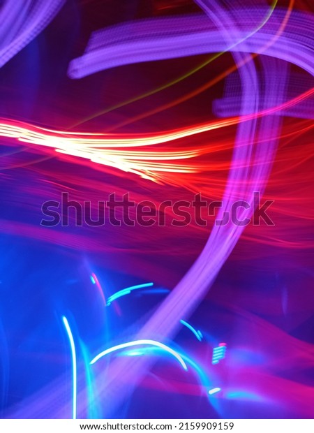 Abstract motion curvy urban road with neon light\
motion effect applied . Automobile background use concept. Light\
trails long exposure highway. Blue and Purple light painting\
photography long\
exposure