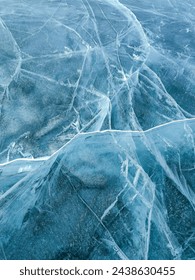 Abstract natural ice texture. Freezy ice surface. Blue backdrop with cracks and scratches on frozen water.