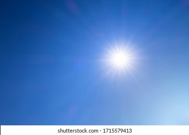 Abstract nature background of Beautiful sunny dark blue sky with bright sun shining with sunbeam, sunlight, sun rays & flares during  midday at tropical summer or spring daylight sunshine day, space  