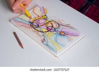 Abstract neurographic drawing with pen and colored pencils. Close-up of hands drawing neurographic art. Neurographic Art - a modern method of art therapy - Shutterstock ID 2237737127