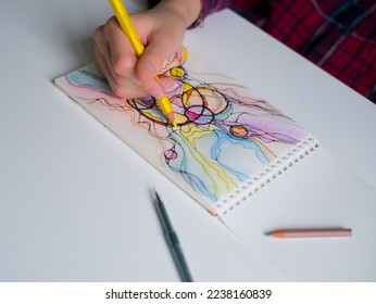 Abstract neurographic drawing with pen and colored pencils. Close-up of hands drawing neurographic art. Neurographic Art - a modern method of art therapy - Shutterstock ID 2238160839