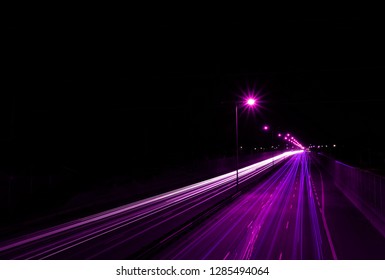 Abstract night city road shot with long exposure, purple light traces lines on the street, aerial view. Digital information, high travel speed effect, dui, careless, dangerous, drunk driving concept.