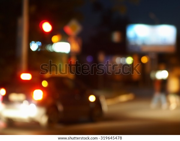 Abstract night scene with dim lights and\
headlights. Blur and defocused lights from the headlights of cars\
and traffic lights can be used as\
background.