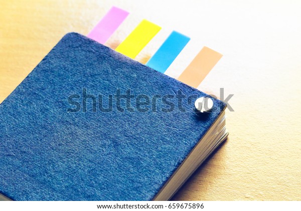 Abstract notebook with\
color note tab.