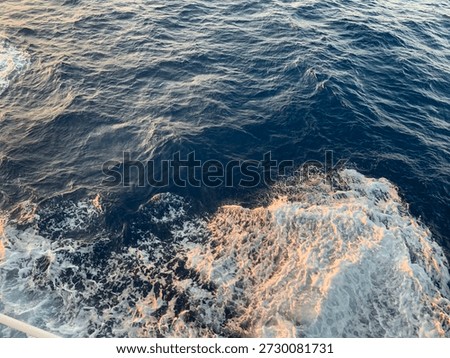 Abstract ocean surface with deep blue sea water and white foamy waves, captured from above in natural light, ideal for marine, travel, and background concepts.