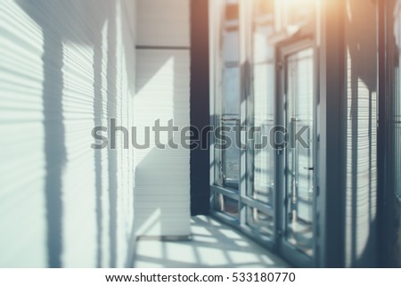 Abstract office interior background, the sun rays, glass, steel columns and door, view from skyscraper through the window, Dubai cityscape outside