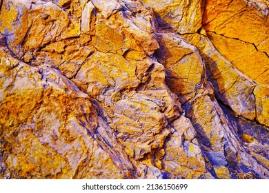    Abstract orange yellow blue background. Colorful rock texture. Cracked layered mountain surface. Close-up. Grungy stone background with space for design.                            