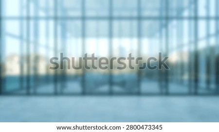 An abstract out of focus background of a spacious corporate building lobby with a glass facade and bright natural light