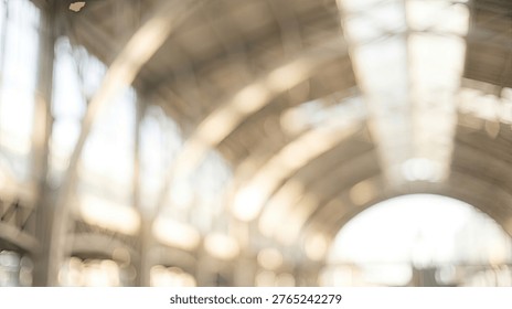 An abstract, out-of-focus image capturing the interior of a large building, possibly a train station or market, with sunlight streaming through the roof.