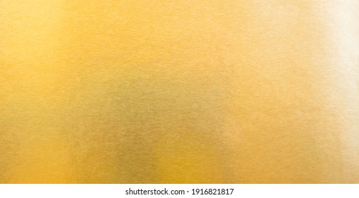 Abstract paper golden for Merry Christmas and Happy new year.
				Gradation gold foil leaf shiny with sparkle yellow metallic texture background.
				top view.
