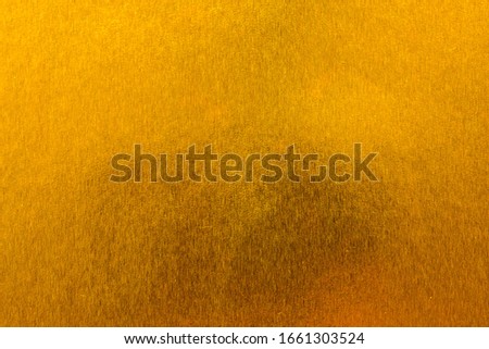 Abstract paper golden for Merry Christmas and Happy new year.
Gradation gold foil leaf shiny with sparkle yellow metallic texture background.
top view.