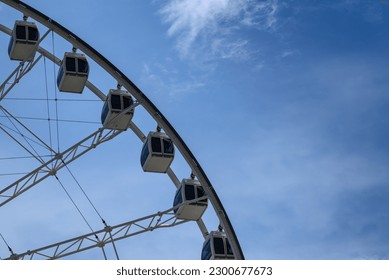 Abstract partial view of a ferris wheel against a clear blue sky