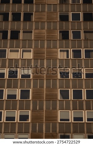 Abstract pattern of apartment building facade with repetitive windows and geometric urban architecture.
