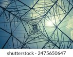 Abstract pattern from bottom view of high voltage pole power transmission tower with backlit sunshine sky background in monochrome. Green energy saving, electrical technology, abstract pattern concept
