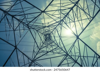 Abstract pattern from bottom view of high voltage pole power transmission tower with backlit sunshine sky background in monochrome. Green energy saving, electrical technology, abstract pattern concept - Powered by Shutterstock