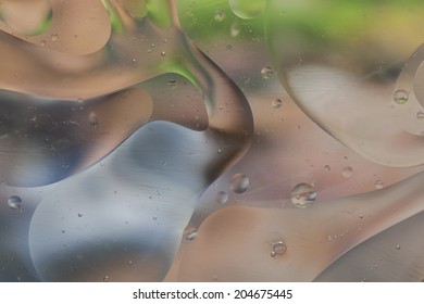Abstract pattern of colored oil bubbles on water