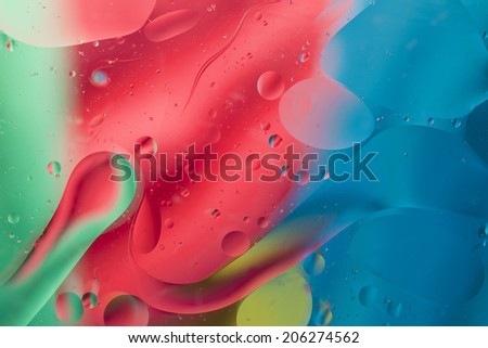 Abstract pattern of colored oil bubbles on water