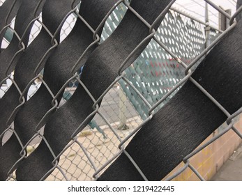 Abstract pattern created by partially woven material through chain-link fencing