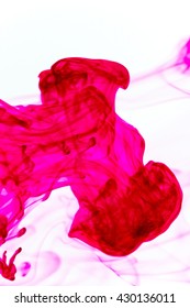 Abstract pattern falling into the water drop of pink ink - pink ink dispersing in water

