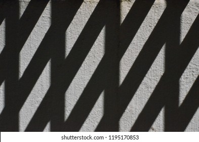 Abstract pattern formed by the shadow odf a fireescape on a grey wall