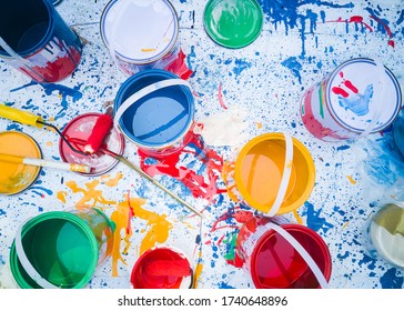 Abstract pattern with multicolored oil paintings with brushes Acrylic color top down, Can of paints with the motion of colored explosions Paints in tin buckets, and brushes on white canvas background.