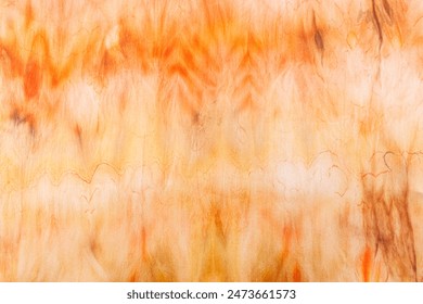 abstract pattern on silk fabric texture in yellow and brown tones close-up