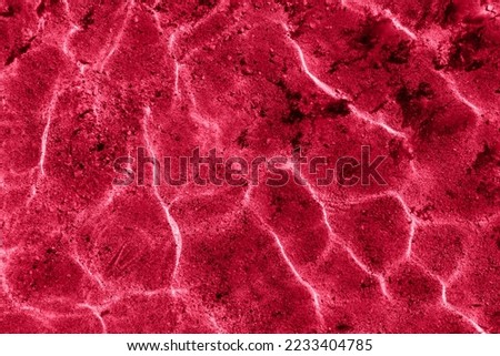 Abstract pattern sea water caustic texture background with pattern of ripple wave and sun reflection. Image toned in color of the year 2023 viva magenta