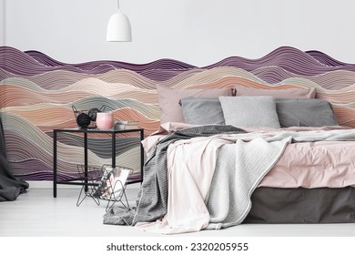 Abstract pattern wall decal or wallpaper on white wall with bed along with side table. 