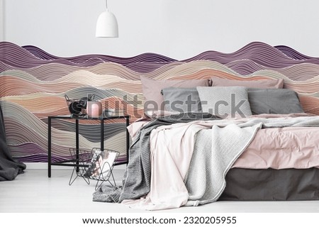 Abstract pattern wall decal or wallpaper on white wall with bed along with side table. 