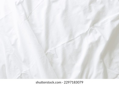 Abstract pattern of white crumpled bed sheet. White wrinkled fabric texture rippled surface. Close up image