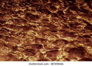 Abstract patterned gold surface water in the pool.