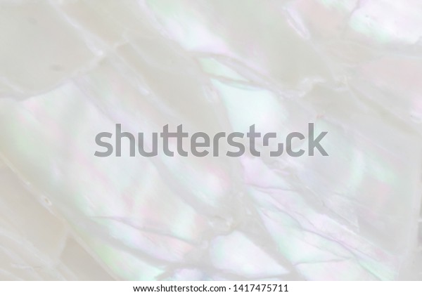 Abstract pearl background with soft\
shimmering mother of pearl lilac and rainbow\
colours