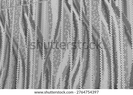 Abstract perforated metal panel with dot pattern in black and white