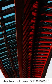 Abstract perspective of modern bridge structure with bold red and blue patterns.