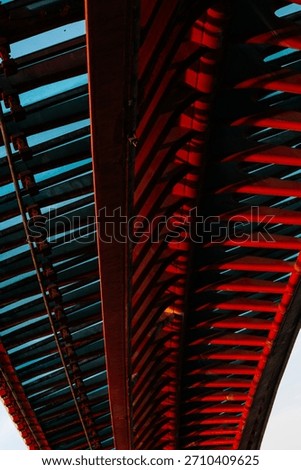 Abstract perspective of modern bridge structure with bold red and blue patterns.