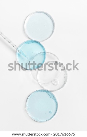 Abstract petri dishes with cosmetic on white background top view. Science cosmetic laboratory concept. Cosmetology research, skin care products.